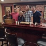 Work team posing inside a speakeasy themed escape room in Columbus Ohio