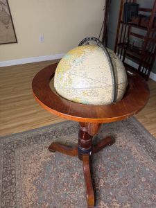 Antique globe displayed on a wooden table in the Explorer's Study escape room